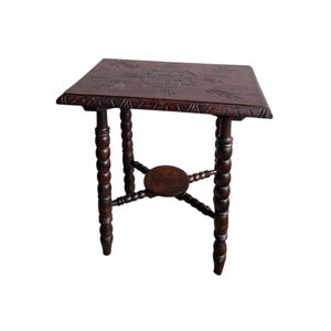 Puede incluir: Mesa auxiliar antigua de madera marrón oscuro con tapa cuadrada y patas torneadas. La tapa presenta diseños florales tallados. La mesa mide aproximadamente 61 cm de altura.
