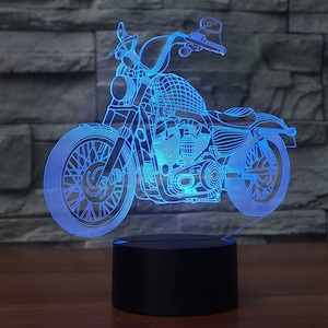 May include: A blue 3D printed motorcycle lamp with a black base. The motorcycle is outlined in blue and has a detailed design.