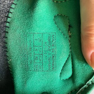 Pu&ograve; includere: Primo piano dell'interno di una scarpa verde con cuciture nere. La taglia della scarpa &egrave; stampata in nero su un'etichetta bianca: "US 7.5, UK 6.5, EUR 39, CM 24.5".