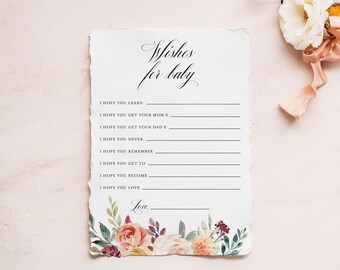 Può includere: Un biglietto di auguri per baby shower con la scritta "Wishes for baby" in elegante corsivo. Il biglietto presenta un motivo floreale nella parte inferiore con accenti pesca, bordeaux e verdi. Un bouquet di fiori con un nastro rosa è sullo sfondo.