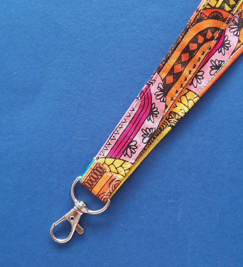 A fun fabric lanyard with a colourful funky rainbow design. With a silver coloured lobster swivel clasp.