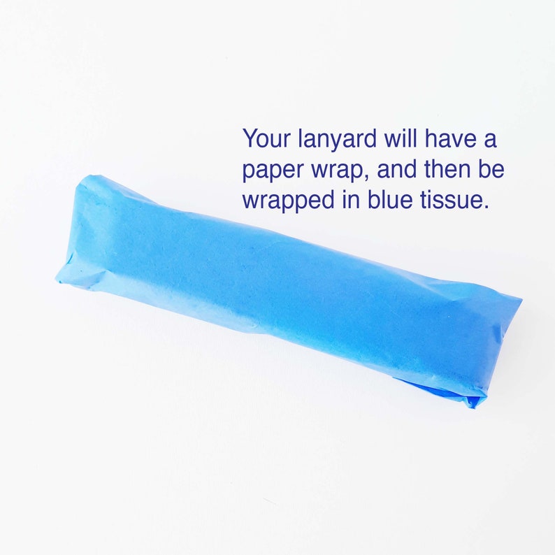 May include: A blue tissue paper wrapped package with the text "Your lanyard will have a paper wrap, and then be wrapped in blue tissue."