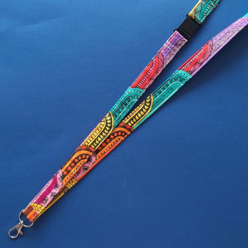 A fun fabric lanyard with a colourful funky rainbow design. A camper van appears occasionally across the print. This option does not have the loops.