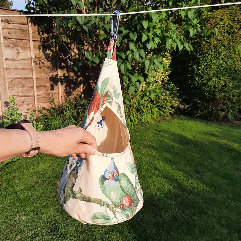 A peg bag with a conical shape.  Great for storing clothespins, craft items etc. A large carabiner clips to the washing line. To store, the top flips over and the carabiner clips into a loop to close.