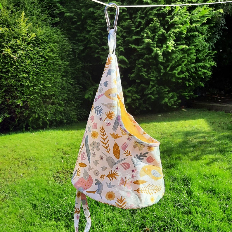 Photo shows an XXL sized peg bag hanging from a washing line.