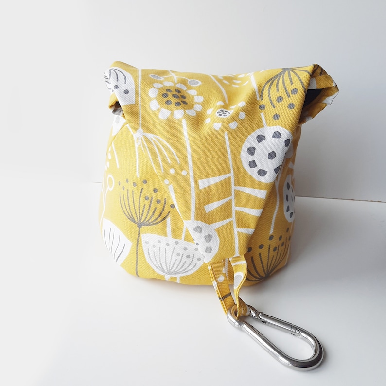 A peg bag with a conical shape.  Great for storing clothespins, craft items etc. A large carabiner clips to the washing line. To store, the top flips over and the carabiner clips into a loop to close.