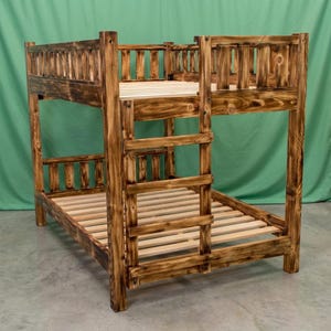 May include: A bunk bed frame constructed from dark stained wood with a visible grain pattern. The structure features a slatted design on both the upper and lower levels, with a built-in vertical ladder on the side and protective railings.