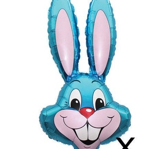 Pode incluir: Um balão azul em forma de cabeça de coelho com orelhas cor-de-rosa e um sorriso branco.