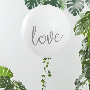 Può includere: Pallone bianco con la parola "love" scritta in grigio con un piccolo cuore al centro della "o".