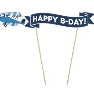 Puede incluir: Dos adornos para pasteles de papel azul y blanco con palitos de madera. Un adorno es un avi&oacute;n azul con lunares blancos y el otro es una pancarta azul con costuras blancas que dice "HAPPY B-DAY!"