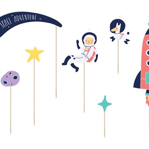 May include: A set of six space-themed cake toppers. The toppers feature a rocket, an astronaut, a star, a moon, a llama, and a banner that says "Space Adventure".