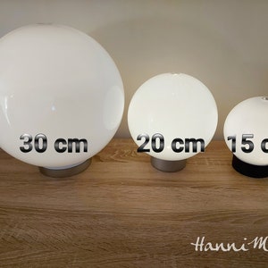 May include: Three white glass globe lamps of different sizes. The largest lamp is 30 cm in diameter, the middle lamp is 20 cm in diameter, and the smallest lamp is 15 cm in diameter.