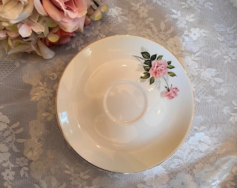 May include: A white saucer with a gold rim and a pink rose floral design.