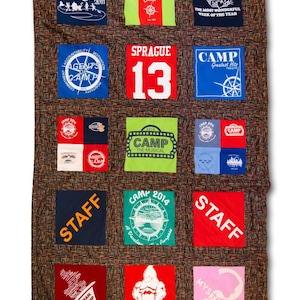 May include: A brown fabric quilt with a patchwork design made from various t-shirts. The t-shirts feature different camp-themed designs, including logos, slogans, and numbers. The quilt is a great way to commemorate a summer camp experience.