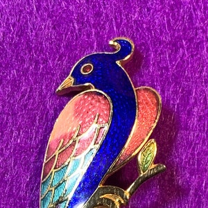 Enameled tropical bird pin featuring a beautiful, feathery tail! Colorful design on gold-tone.