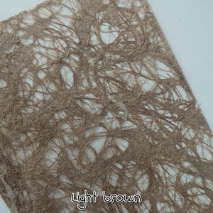 May include: A close-up of a light brown, textured paper with a web-like pattern. The paper has a natural, organic appearance. The words "Light brown" are written in a cursive font at the bottom of the image.