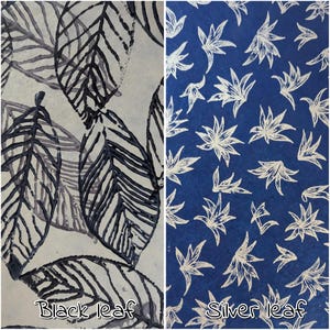 May include: Two fabric samples with leaf patterns. One features black leaves on a light background, the other has silver leaves on a dark blue background. The text "Black leaf" and "Silver leaf" are at the bottom.