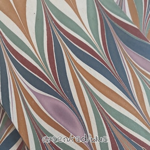 May include: Fabric with a repeating pattern of curved lines in green, red, blue, orange, and purple on a white background. The text "Green/red/blue" is at the bottom. The design is abstract.