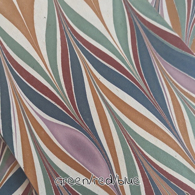 May include: Fabric with a repeating pattern of curved lines in green, red, blue, orange, and purple on a white background. The text "Green/red/blue" is at the bottom. The design is abstract.