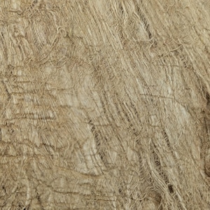 May include: Close-up of a textured, beige fabric with a woven appearance. The material has a rough, fibrous texture with visible strands and a slightly uneven surface. The fabric's color is a warm, neutral tone, suitable for various textile projects.