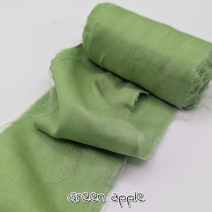 May include: A roll of green apple-colored fabric with a frayed edge, and a length of the same fabric unrolled. The text "Green apple" is written in a cursive font at the bottom of the image.