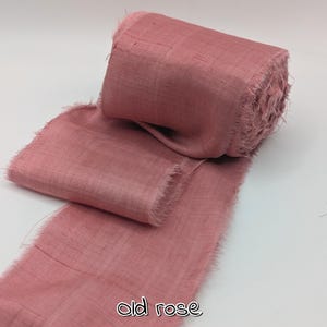 May include: A roll of old rose-colored ribbon with frayed edges. The ribbon is made of a textured fabric and is partially unrolled, revealing its width and texture. The text "old rose" is printed at the bottom.