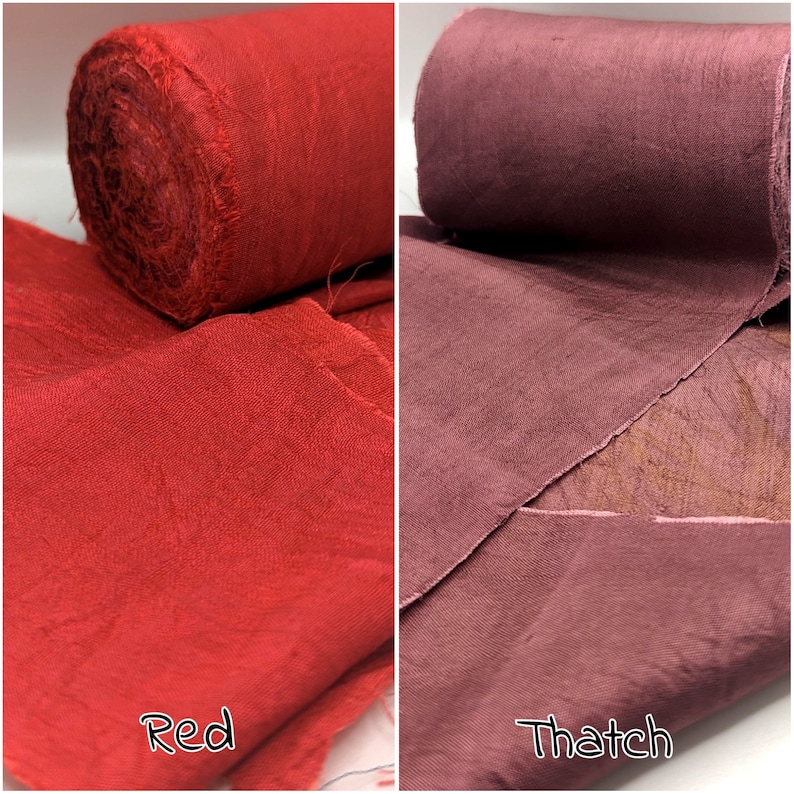 May include: Two fabric rolls, one bright red and the other a muted reddish-brown color. The red roll is labeled "Red" and the other "Thatch". The fabric appears to be a textured weave, possibly linen or cotton.