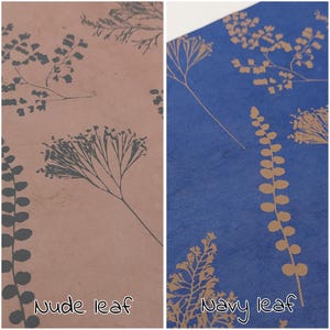 May include: Two sheets of paper with botanical designs. One is nude with dark gray leaf patterns, the other is navy blue with gold leaf patterns. The text "Nude leaf" and "Navy leaf" are visible at the bottom of each sheet.