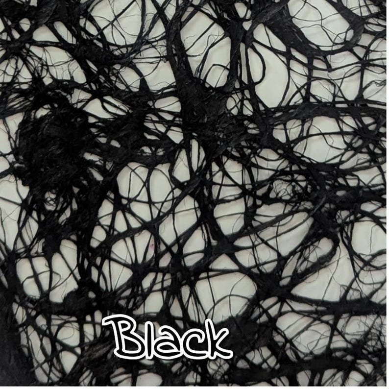 May include: Close-up of a black, textured fabric with a web-like pattern. The fabric has a network of thick, dark lines against a lighter background. The word "Black" is written in a white, stylized font.