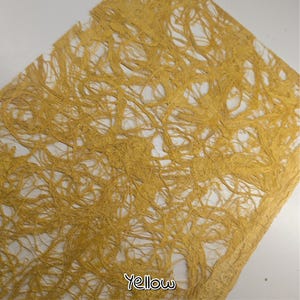 May include: A sheet of handmade paper with a textured, fibrous appearance. The paper is a warm yellow color, with the word "Yellow" printed in a script font in the bottom left corner. The paper has a unique, organic look.