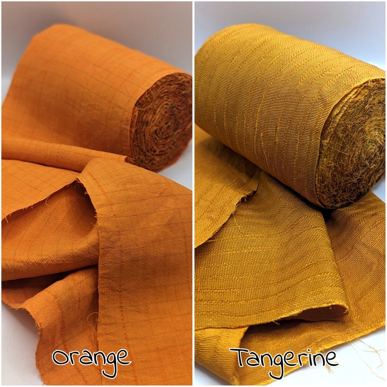 May include: Two rolls of orange and tangerine fabric. The orange fabric is unrolled, showing the texture and weave. The tangerine fabric is rolled up, with a portion unrolled. The words "Orange" and "Tangerine" are written on the image.