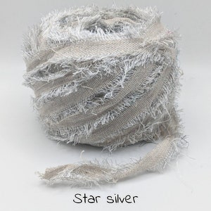 May include: A roll of star silver ribbon. The ribbon is a light tan colour with frayed edges and silver metallic threads woven throughout. The text "Star silver" is written in a handwritten font at the bottom of the image.