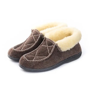 May include: A pair of brown quilted slippers with a faux fur lining. The slippers have a closed toe and a slip-on design.