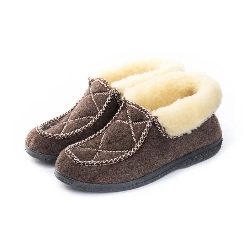 May include: A pair of brown quilted slippers with a faux fur lining. The slippers have a closed toe and a slip-on design.
