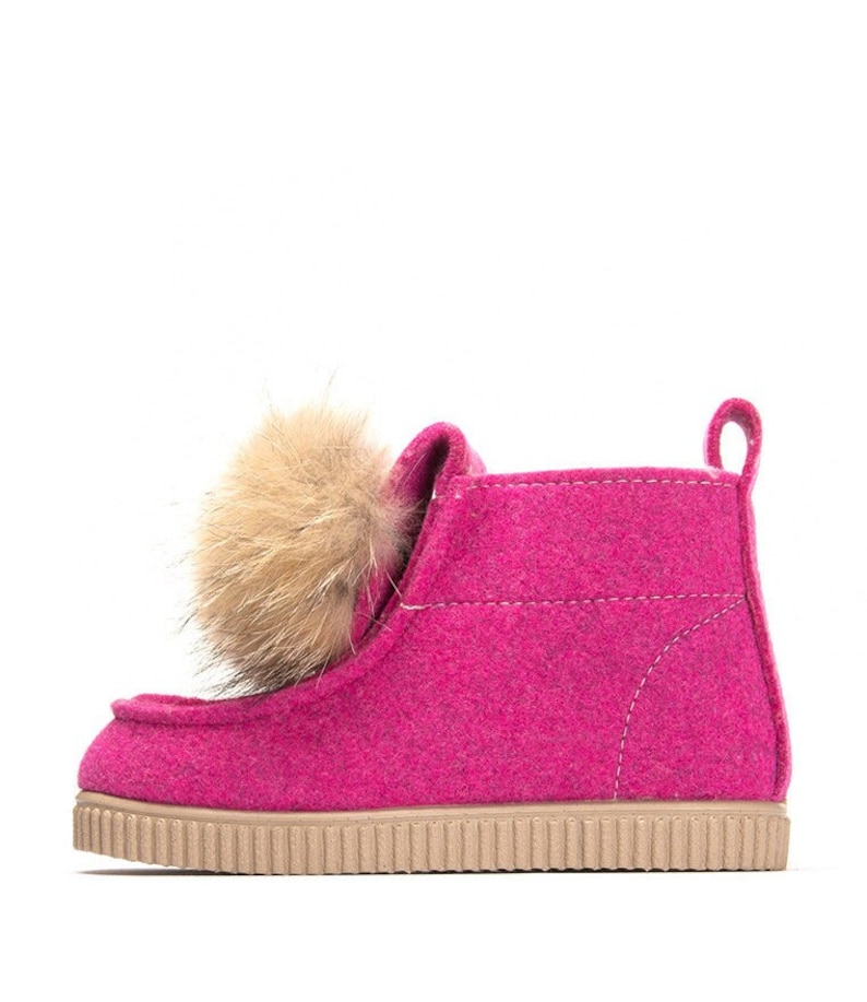 May include: Pink felt ankle boots with a faux fur pom-pom on the top.
