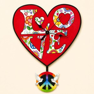 May include: A heart-shaped wall clock with the word "LOVE" in white, floral-patterned letters against a red background. The clock has black hands and a peace sign pendant with doves and a rainbow.