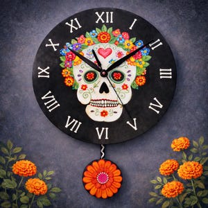 May include: A black wall clock featuring a Day of the Dead sugar skull design. The skull is white with colorful floral accents, a red heart, and floral crown. The clock has black hands, white Roman numerals, and a decorative orange flower pendulum.