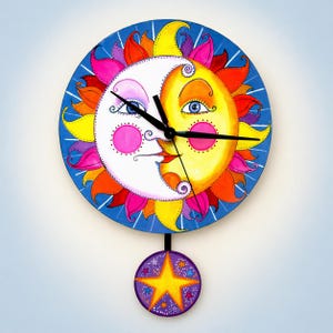 May include: A whimsical wall clock featuring a smiling sun and moon design. The clock face is a vibrant blue with a colorful sun and moon illustration. A purple star pendulum hangs below. The clock hands are black.