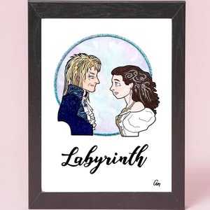 May include: A framed illustration of two characters from the movie Labyrinth. The characters are a man with long blonde hair and a woman with long brown hair. They are standing in front of a blue and purple circle with a sparkly border. The text "Labyrinth" is written in black cursive below the characters.