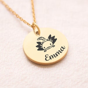 May include: Gold necklace with a round pendant featuring a black axolotl illustration and the name "Emma" engraved on it.