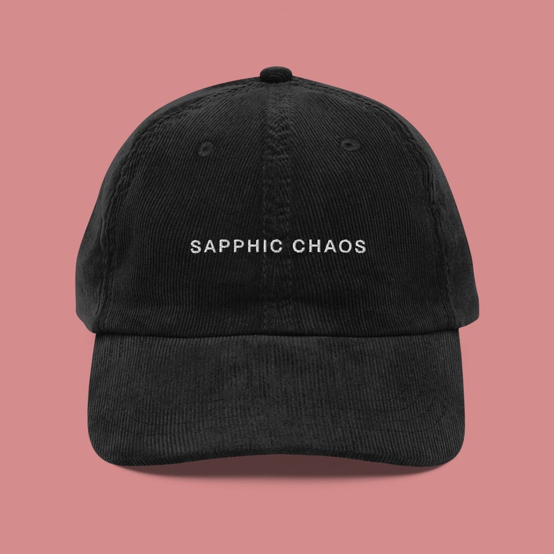 May include: A black corduroy baseball cap with white embroidered text that reads "SAPPHIC CHAOS".
