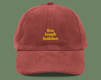 May include: A red corduroy baseball cap with the text "live laugh lesbian" embroidered in yellow.