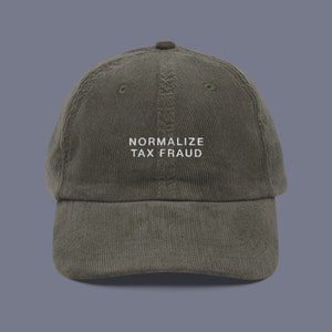 May include: A green corduroy baseball cap with the text "NORMALIZE TAX FRAUD" embroidered in white on the front.
