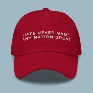 May include: Red baseball cap with white embroidered text that reads "Hate Never Made Any Nation Great".