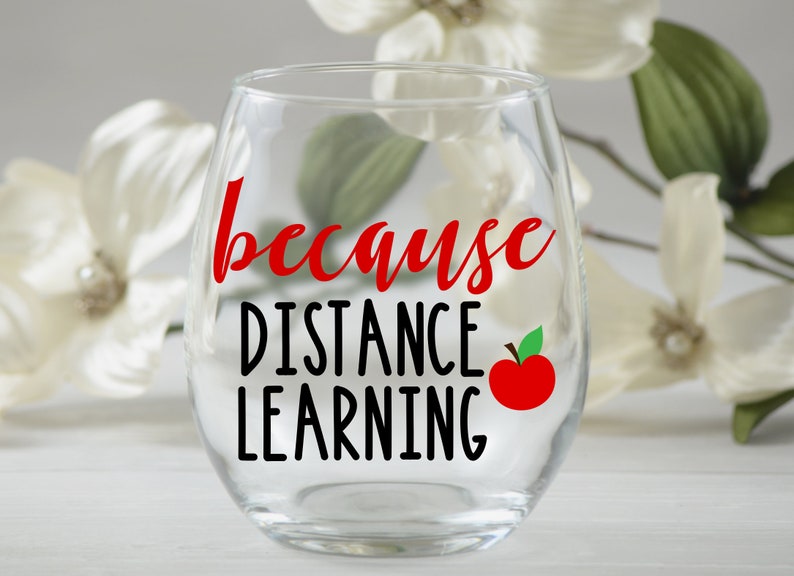May include: A clear glass wine glass with the text "because distance learning" in black lettering and a red apple graphic.