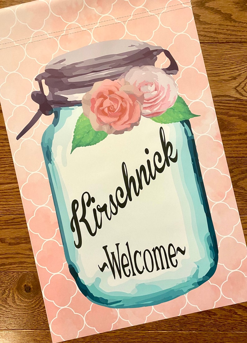 May include: A blue mason jar with a pink and white floral design and the text "Kirschnick -Welcome-" on a pink background with a white geometric pattern.