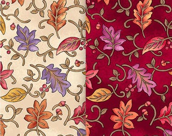 May include: Two fabric swatches with a fall leaf pattern. The left swatch is a cream color with brown, orange, yellow, and purple leaves. The right swatch is a deep red color with brown, orange, yellow, and purple leaves.