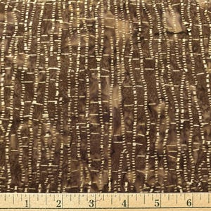 May include: Close-up of a brown fabric with a textured pattern. The design features vertical lines of small, evenly spaced white dashes, creating a grid-like effect. The fabric has a mottled appearance with variations in brown tones.