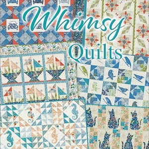 May include: A book cover with the title "Whimsy Quilts" in teal lettering. The cover features four different quilt designs with a variety of colors and patterns, including blue, green, orange, and white. The text "Temporary Cover" is at the bottom of the cover.