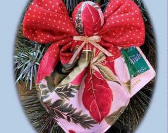 May include: A red and white fabric angel ornament with a gold cross. The angel is sitting on a green pine branch. Stitch a dozen pocket angels to give as gifts or decorate your tree. Includes detailed folding instructions with full colored photos.